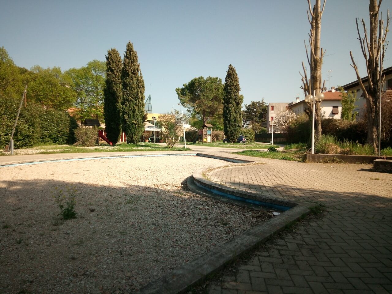 Un ex piscina con fontana, ora riempita con i sassi